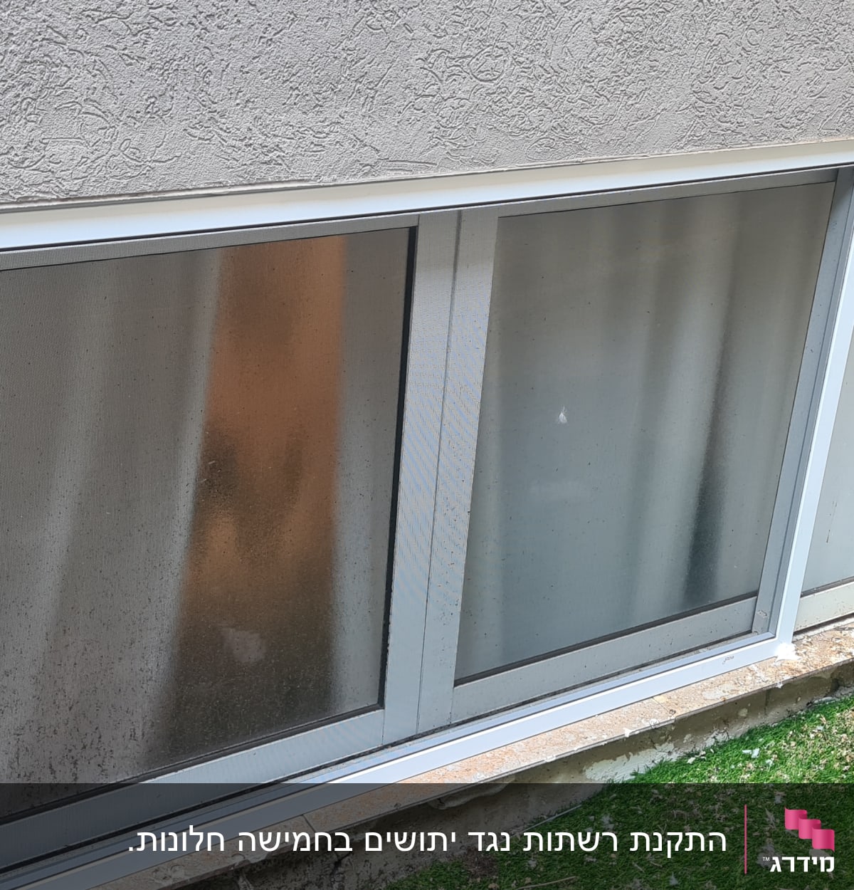 חלון אלומיניום עם מסגרת לבנה בקיר חיצוני